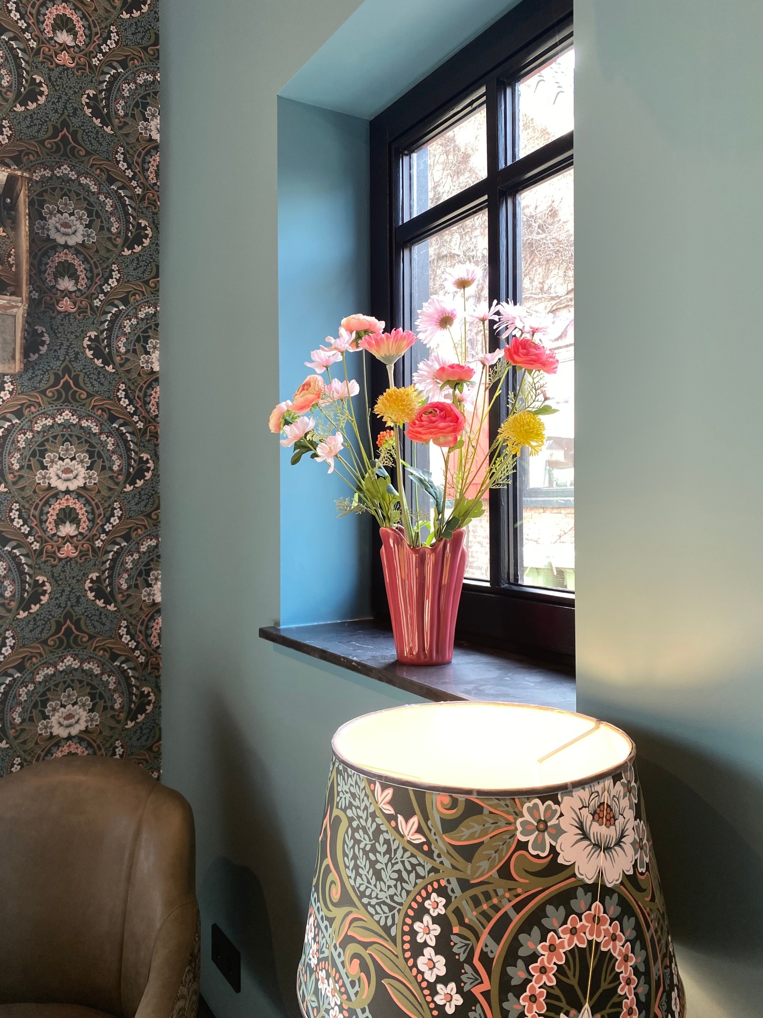 Bloemen in een vaas bij het raam met vintage lamp